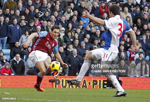 Aston Villa's English midfielder Stewart Downing scores their third goal during the English Premier League football match between Aston Villa and...