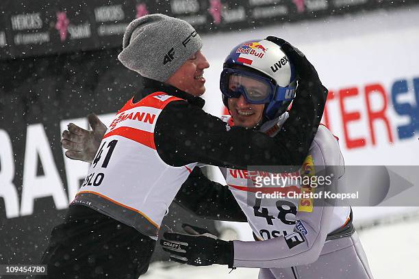 Adam Malysz of Poland is congratulated by teammate Kamil Stoch of Poland after winning the bronze medal in the Men's Ski Jumping HS106 competition...
