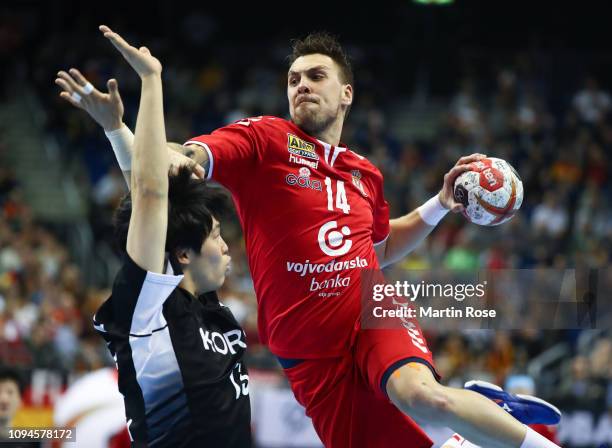 Song Jin Ri of Korea hallenges Bogdan Radivojevic of Serbia during the 26th IHF Men's World Championship group A match between Korea and Serbia at...
