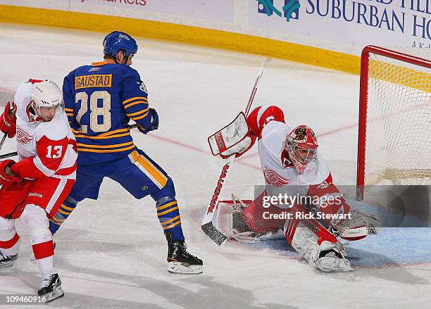 Joey MacDonald of the Detroit Red Wings makes a glove save as Paul Gaustad of the Buffalo Sabres looks on at HSBC Arena on February 26, 2011 in...