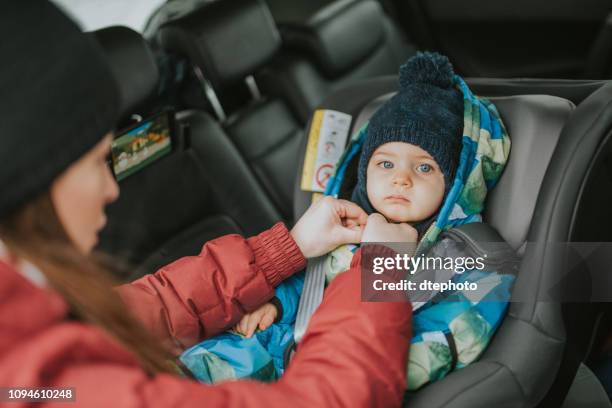 un matrimonio joven con un niño se preocupa por la seguridad vial - anorak fotografías e imágenes de stock