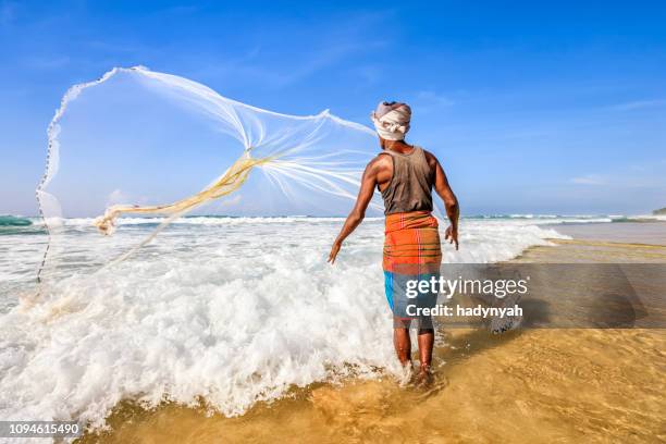 sri lankan fisherman throwing a fishing net near mirissa - sri lanka fisherman stock pictures, royalty-free photos & images