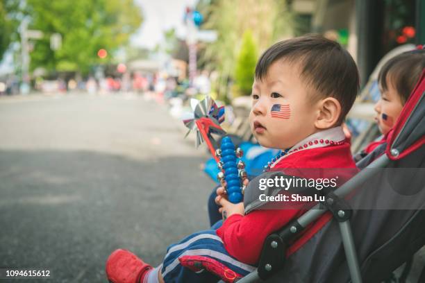 adorable asian boy celebrating fourth of july. - america parade stock-fotos und bilder