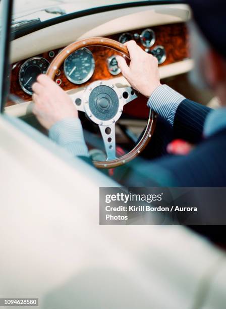 man driving luxury antique car - luxury car stock-fotos und bilder