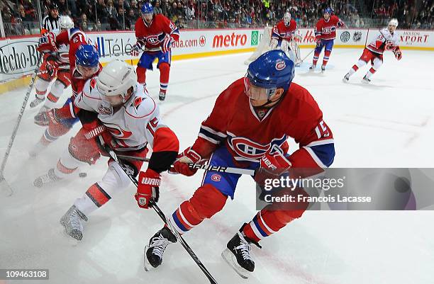 Jeff Halpern of the Montreal Canadiens and Tuomo Ruutu of the Carolina Hurricanes battle for the puck along the boards during the NHL game on...