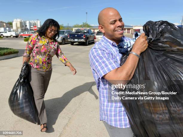 Jose Silva, executive director of The Pearl Group, and Valerie Whatley, Life Bridge Church's Single Parent Services coordinator, carry donated...