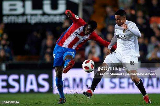 Francis Coquelin of Valencia CF competes for the ball with Isaac Cofie of Sporting Gijon during the Copa del Rey Round of 16 second leg match between...