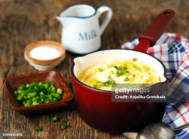 mashed potato in cooking pan on wooden background, copy space - potato masher stockfoto's en -beelden