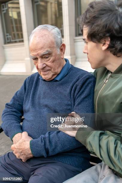 ill old man being assisted by a young man - lost generation stock pictures, royalty-free photos & images