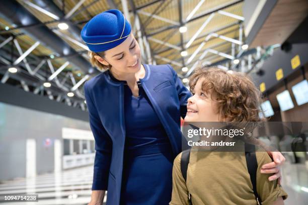 flight attendant taking care of a boy traveling alone at the airport - air stewardess stock pictures, royalty-free photos & images