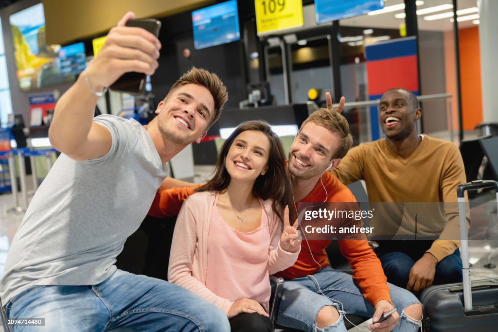 Group of friends traveling together and taking a selfie at the airport