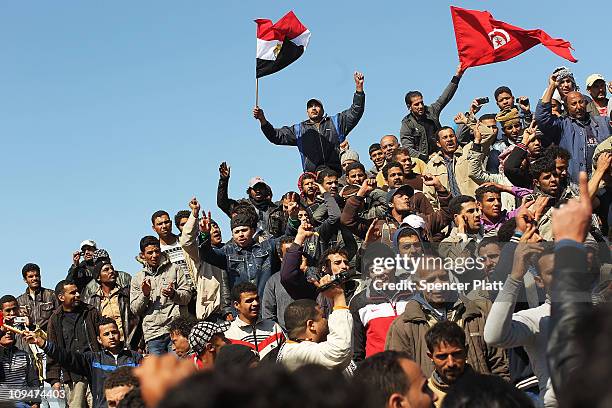 Waving Egyptian and Tunisian flags, migrant workers who recently fled into Tunisia from Libya demand to be taken home during a demonstration at a...