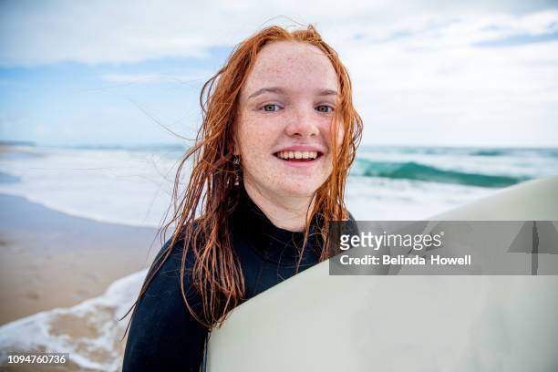 red haired, australian surfer girl spends time at the beach - youth culture australia stock pictures, royalty-free photos & images
