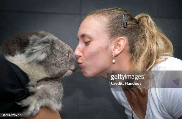 In this handout image provided by Tennis Australia, Elise Mertens of Belgium kisses a koala during day three of the 2019 Australian Open on January...