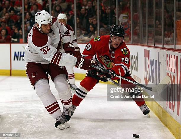 Michal Rozsival of the Phoenix Coyotes and Jonathan Toews of the Chicago Blackhawks battle for the puck at the United Center on February 27, 2011 in...