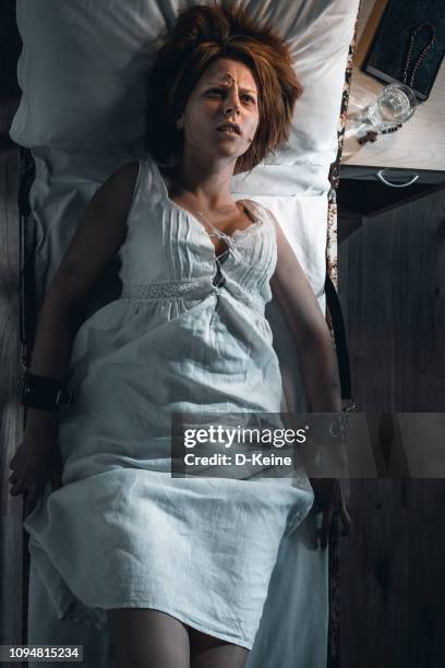 donna in bizzaffo in camera d'ospedale buia - restraining device foto e immagini stock