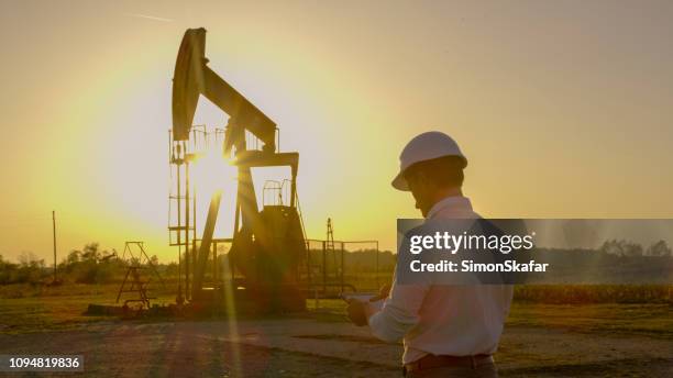 engineer near pumpjack - oil field stock pictures, royalty-free photos & images