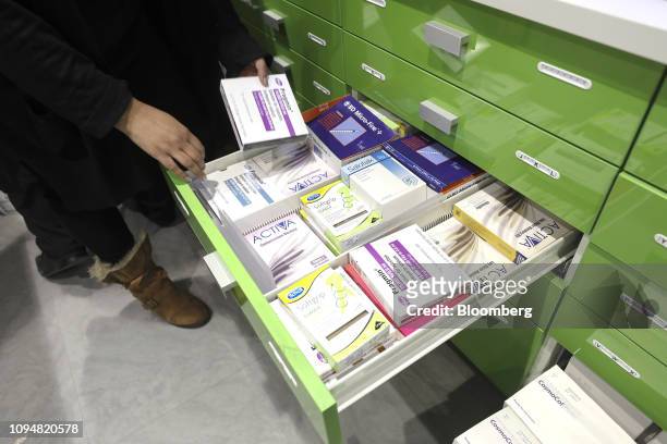 Pharmacist picks up a box of Fragmin, manufactured by Pfizer Inc., from a drawer at Hodgson Pharmacy in Longfield, Kent, U.K., on Tuesday, Feb. 5,...