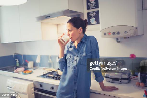 woman drinking milk in kitchen. - woman drinking milk stock pictures, royalty-free photos & images