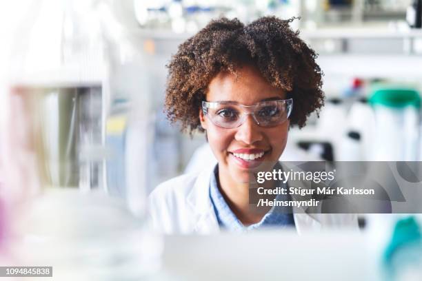 gelukkig wetenschapper het dragen van beschermende brillen in lab - pharma people stockfoto's en -beelden