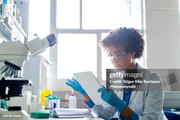 young female scientist using digital tablet in lab - drug discovery stock pictures, royalty-free photos & images