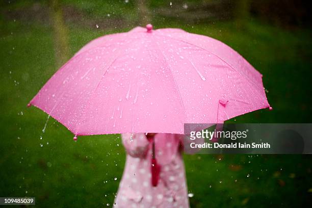 five year old girl stands in garden with umbrella - rain umbrella stock pictures, royalty-free photos & images