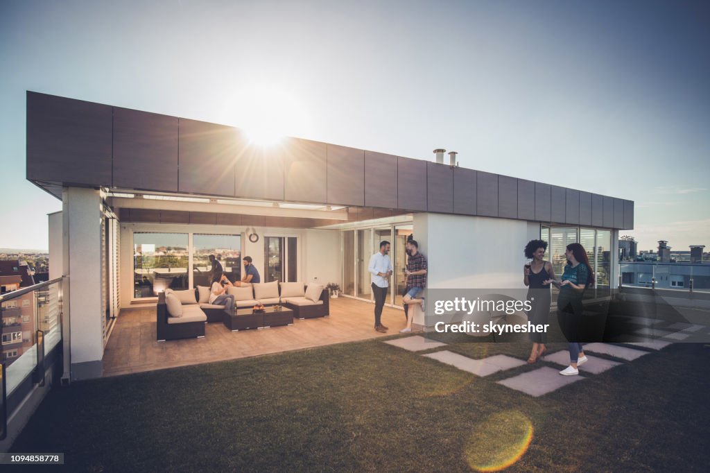 Jungen glücklich Freunde sprechen während ihrer Zeit auf einer Penthouse-Terrasse.