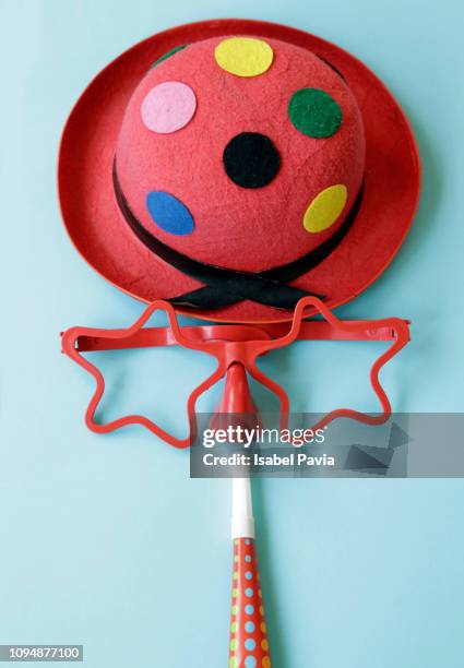 funny clown face formed with hat, glasses, nose and horn blower on blue background - party horn blower bildbanksfoton och bilder