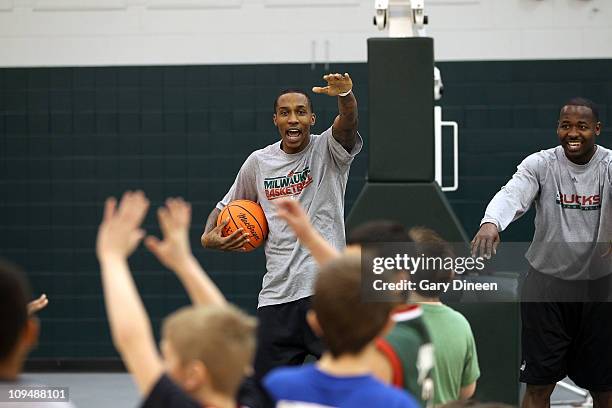 Brandon Jennings of the Milwaukee Bucks and assistant coach Anthony Goldwire work with participants during the YMCA basketball clinic on February 27,...