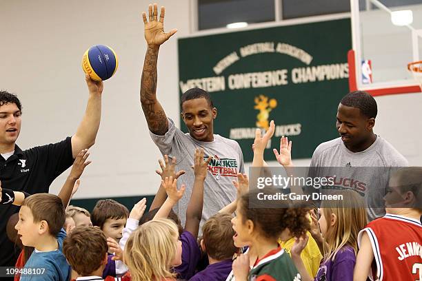 Brandon Jennings of the Milwaukee Bucks and assistant coach Anthony Goldwire work with participants during the YMCA basketball clinic on February 27,...