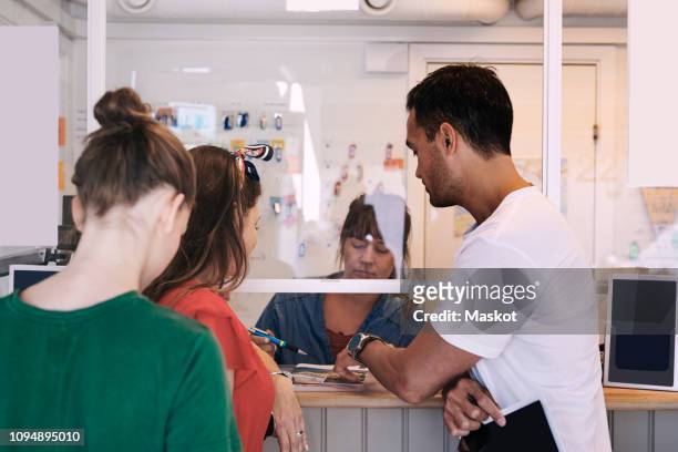 family talking to woman at ticket counter in trailer park - information kiosk stock pictures, royalty-free photos & images