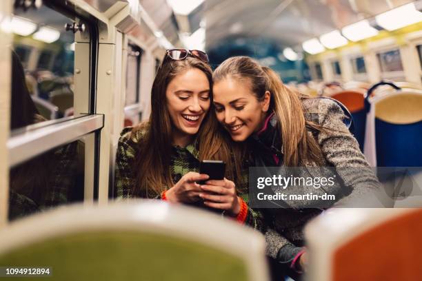 schöne mädchen in der u-bahn unterwegs und spaß in den sozialen medien - u bahnzug stock-fotos und bilder