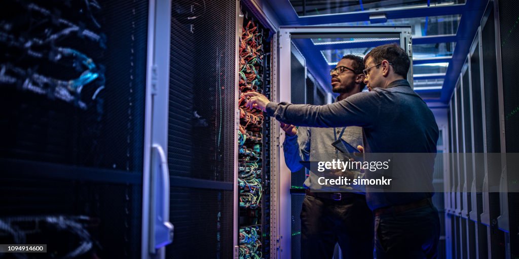 IT engineers checking servers in server room