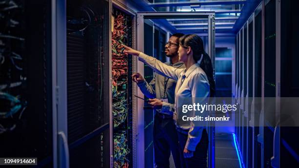 it engineers checking servers in server room - equipamento de computador imagens e fotografias de stock