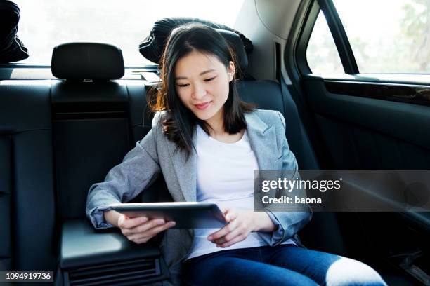 zakenvrouw met behulp van digitale tablet in auto - auto tablet stockfoto's en -beelden