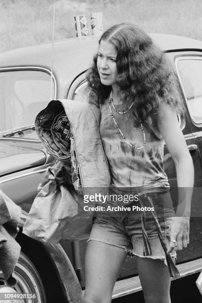 Festival-goer abandons her vehicle in a traffic jam on the way to the Woodstock Music Festival, Bethel, New York, 15th August 1969.