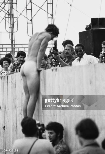 Naked man climbing a barrier at the Woodstock Music Festival, Bethel, New York, 15th-17th August 1969.