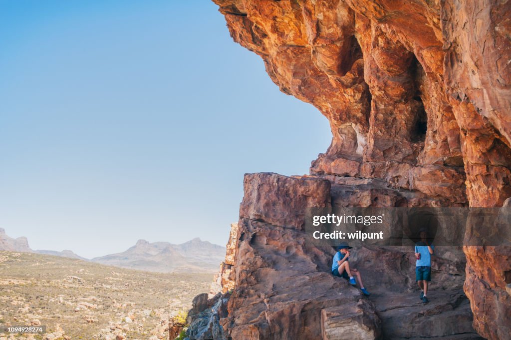 Two brothers sitting in a cave