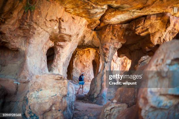 frau zu fuß durch eine sandstein-höhle - spelunking stock-fotos und bilder