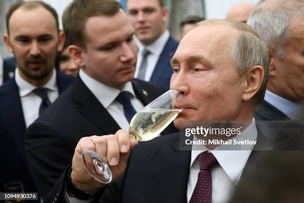 Russian President Vladimir Putin drinks champaigne during the awarding ceremony for young scientists at the Kremlin February 7, 2019 in Moscow,...