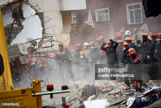 Rescue workers search the rubble of an eight-storey building which collapsed the previous day in the Kartal district of the Turkish city of Istanbul,...