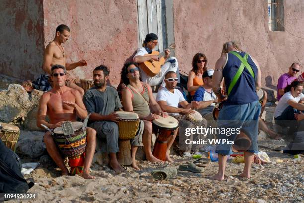 People enjoying sundays in popular Benirras beach, where drum players play until sunset, Ibiza, Spain.