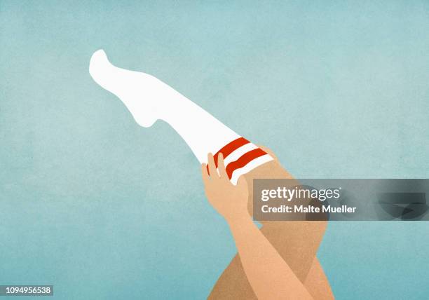 woman putting on knee high socks - leg stock-grafiken, -clipart, -cartoons und -symbole