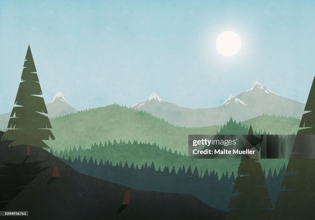 Sun shining over idyllic mountain and forest landscape