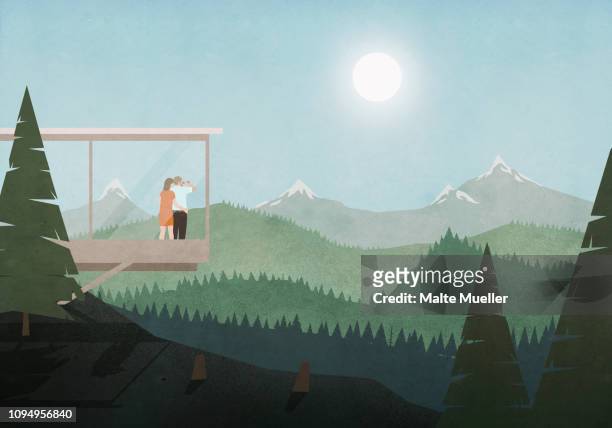 couple looking at idyllic, sunny mountain and forest view from glass house - aussicht genießen stock-grafiken, -clipart, -cartoons und -symbole