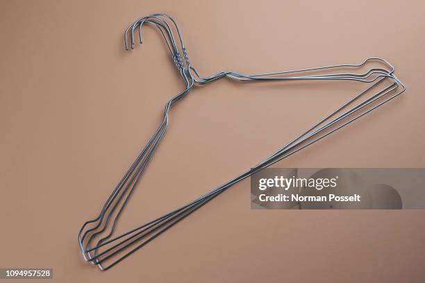 wire hangers on beige background - coathanger photos et images de collection