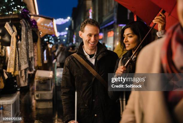 genieten van het wandelen rond de kerstmarkt - iemand een plezier doen stockfoto's en -beelden