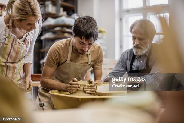 small group of people creating pottery - potters wheel stock pictures, royalty-free photos & images