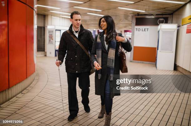 leaving the subway station together - disability support stock pictures, royalty-free photos & images