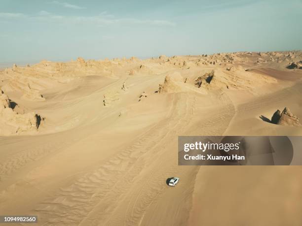 aerial view of white car on desert road - car exterior rear high angle stock-fotos und bilder